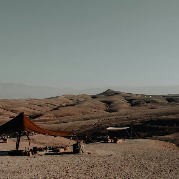 A camp tent in the Agafay desert with the Atlas mountains behind